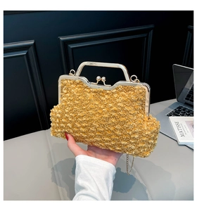 Détail d'un sac en tweed jaune avec cadre doré, fermoir perle et bandoulière chaîne