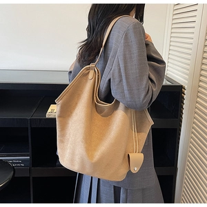 Vue détaillée du sac cabas en daim camel avec fines bretelles et pochette assortie