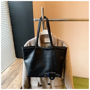Detail of black leather tote bag with a unique glasses holder and double shoulder straps