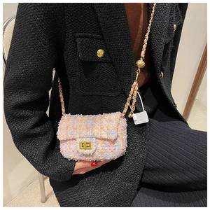 Detail of tweed crossbody bag with gold turn-lock and adjustable metal ball chain strap