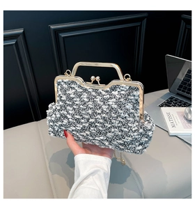 Détail du sac de soirée en tweed avec fermoir perle, poignée métal et chaîne dorée