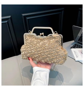 Détail d'un sac en tweed doré avec fermoir à baiser, poignée en métal et bandoulière