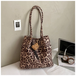 Detail of leopard print canvas tote bag featuring a cute plush bear pendant and large capacity