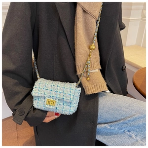 Close-up of light blue tweed mini flap bag with gold chain and ball detail