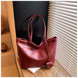 Detail of dark red tote bag with lychee texture PU leather and matching accessory pouch