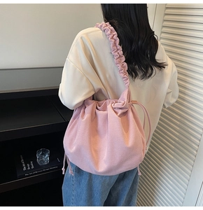 Detail der rosa Cord-Schultertasche mit plissiertem Riemen und Kordelzug-Design