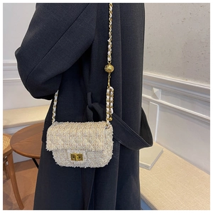 Detail of tweed crossbody bag with golden chain strap and adjustable ball buckle