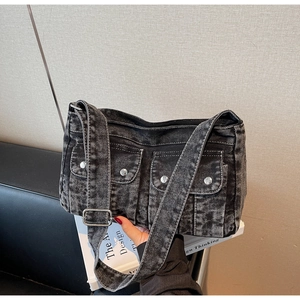 Détail du sac bandoulière en denim délavé avec poches à rabat et boucles argentées