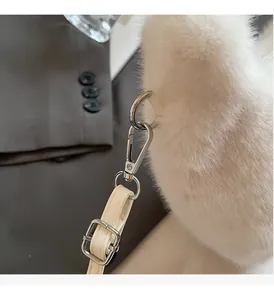 Detail of premium silver metal buckle and soft white plush texture on a stylish handbag