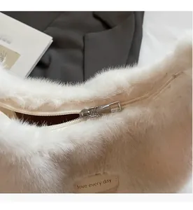 Detail of silver metal zipper and 'love every day' tag on the plush faux fur handbag