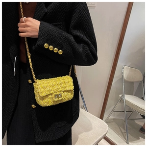 Detail of yellow tweed crossbody bag with gold chain strap and metallic turn-lock closure