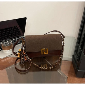 Detail of retro crossbody bag with suede finish and unique beaded metal chain strap