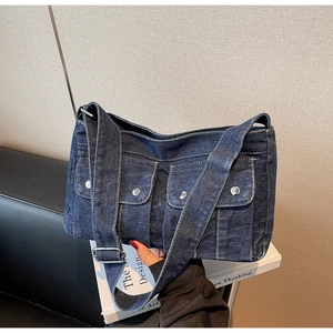 Détails du sac bandoulière en denim bleu foncé avec boucles argentées et surpiqûres