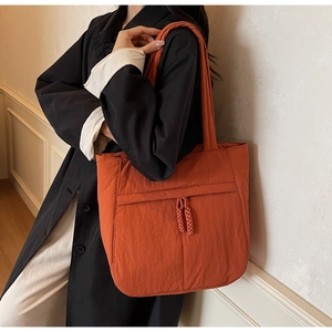 Detailansicht der großen orangefarbenen Nylon-Tragetasche mit Fronttasche und Knoten