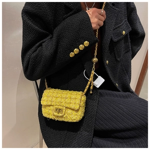 Detail of yellow tweed mini crossbody bag with golden chain and ball adjustment