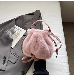 Detail of pink faux fur bucket bag featuring drawstring closure and leather handle