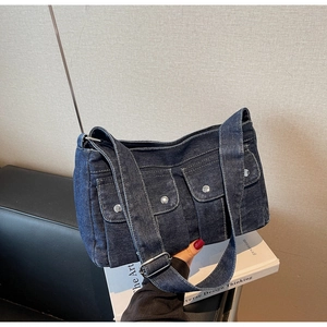 Détail du sac en jean délavé bleu avec rivets argentés et design multi-poches
