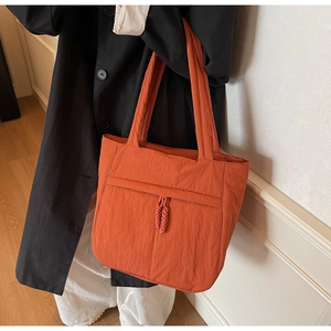 Detail einer großen orangefarbenen Tragetasche mit gewebtem Kordelzug und Nylonstruktur