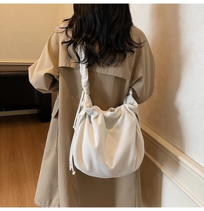 Detailansicht einer weißen Cord-Schultertasche mit plissiertem Kordelzug-Design