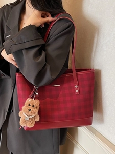 Fashionable red and black checkered tote bag with puppy charm shown on model