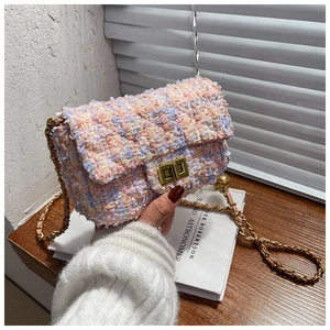 Close-up of multi-color tweed crossbody bag with golden chain and metallic twist lock