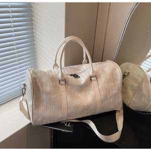 Gros plan d'un grand sac de voyage blanc avec texture tressée en cuir raffinée
