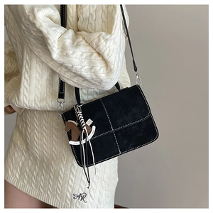 Detail of black crossbody square bag with white contrast stitching and a horse charm