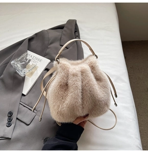 Detail of plush beige bucket bag with drawstring closure and stylish top handle