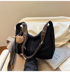 Dettaglio della borsa tote nera con finiture in pelle marrone e cuciture a contrasto