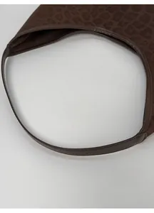 Detailed macro view of the dark brown leopard print tote bag with brown leather handles