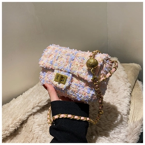 Close-up of pink and blue tweed crossbody bag with golden chain and metal ball adjuster