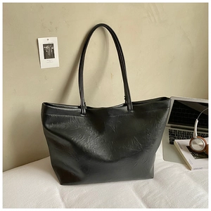 Minimalist black leather tote bag shown with office essentials for a commuter lifestyle