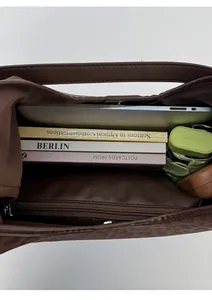 Macro view of a large brown tote bag showing its spacious interior capacity and compartments