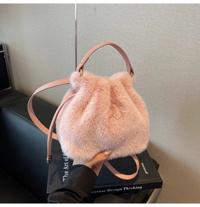 Detail of pink faux fur bucket bag featuring drawstring closure and leather handle