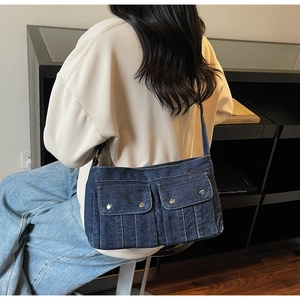 Sac bandoulière en jean délavé avec boucles métalliques argentées sur les poches avant