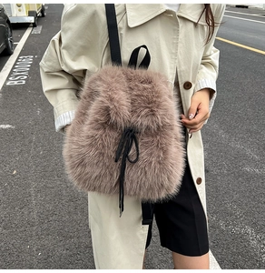 Close-up of fluffy faux fox fur texture and nylon drawstring on stylish backpack