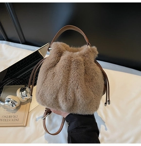 Detail of plush faux fur drawstring bucket bag with leather strap and metal clasp