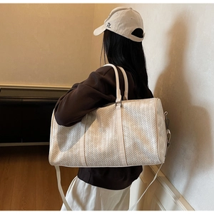 Détail du sac cabas tressé blanc montrant sa grande capacité et sa bandoulière amovible
