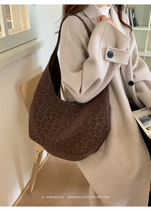 Minimalist brown leopard print hobo bag worn by a model in a cozy indoor setting