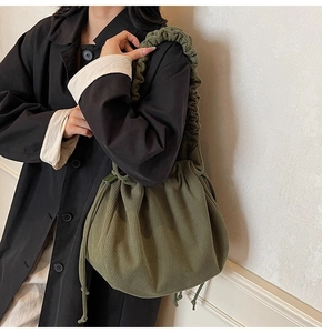 Nahaufnahme der olivgrünen Cordtasche mit weicher Rippstruktur und gefalteten Trägern