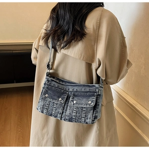 Détail du sac bandoulière en denim délavé bleu avec boucles et bandoulière réglable