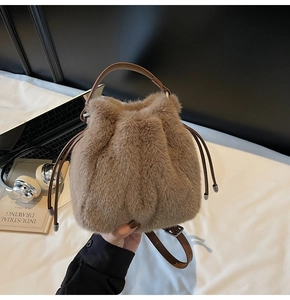 Detail of dark khaki faux fur bucket bag with drawstring closure and leather handle