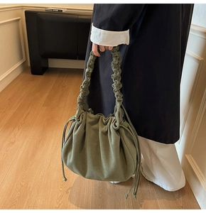 Detail der olivgrünen Cord-Schultertasche mit plissiertem Riemen und Tunnelzug-Textur