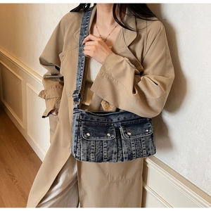 Détail d'un sac bandoulière en denim délavé avec poches cargo et rivets argentés élégants