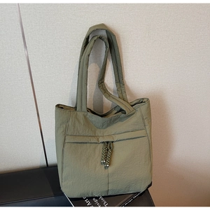 Detail der olivgrünen gesteppten Nylon-Einkaufstasche mit Kordelzug und geflochtenen Quasten
