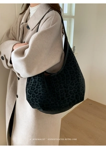 Detail of large leopard print hobo bag worn by model showing suede texture and retro vibe
