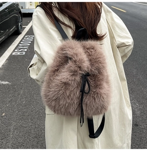 Detail of plush brown backpack featuring black nylon straps and drawstring closure
