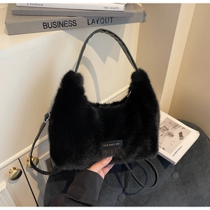 Close-up of black fuzzy plush tote bag with leather straps and love every day label