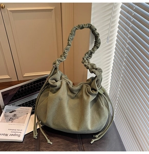 Detailansicht der salbeigrünen Cord-Hobo-Tasche mit einzigartig gefaltetem Wolkengriff-Design