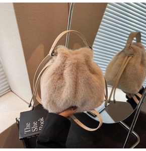 Close-up of fluffy faux fur bucket bag with leather handle and drawstring closure